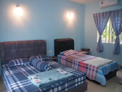 a bedroom with two beds and a window at D'Binjai Homestay & Roomstays Kuala Kangsar in Kuala Kangsar