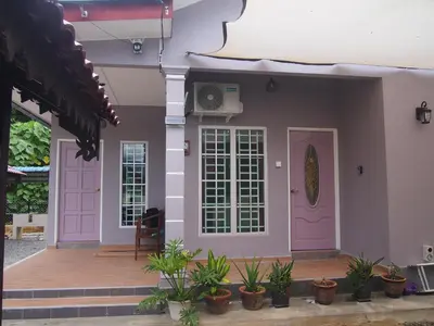 a house with pink doors and potted plants at D'Binjai Homestay & Roomstays Kuala Kangsar in Kuala Kangsar
