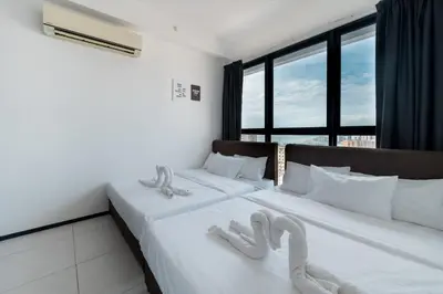 two white beds in a room with large windows at Seaview Infinity Pool 2BR 2CP 8Pax Urban Suite 251 in George Town