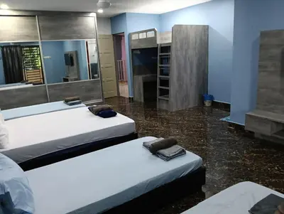 a room with three beds and a mirror at JSW PRAMLee Georgetown Penang in George Town
