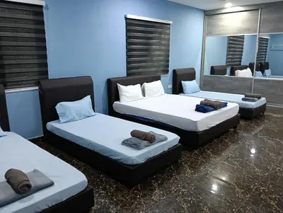 a room with three beds and a mirror at JSW PRAMLee Georgetown Penang in George Town