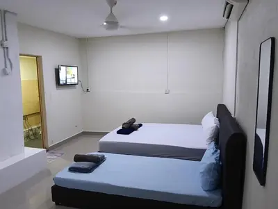 a room with two beds and a tv in it at JSW PRAMLee Georgetown Penang in George Town