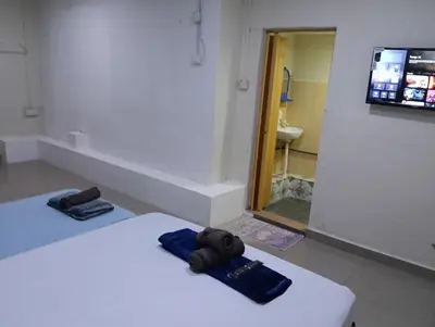 a room with two beds and a bathroom with a sink at JSW PRAMLee Georgetown Penang in George Town