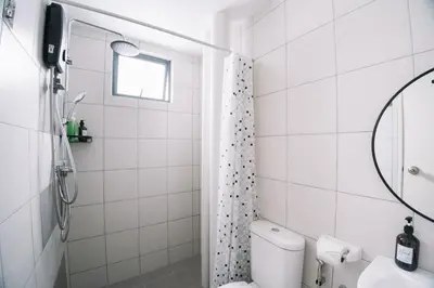 a white bathroom with a toilet and a mirror at NEW The Sun 3Bedrooms 10pax 2CP in Bayan Lepas