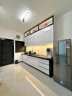 a kitchen with white cabinets and a stainless steel refrigerator at Tpg Creek Lodge in Kamunting