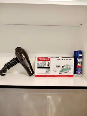 a white counter top with a blow dryer and products on it at Tpg Creek Lodge in Kamunting