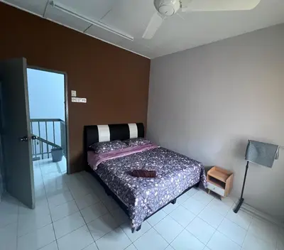 a bedroom with a bed in the corner of a room at Teratak Segar Bayu - Musslim Only Tanjong Malim Perak in TanjongMalim