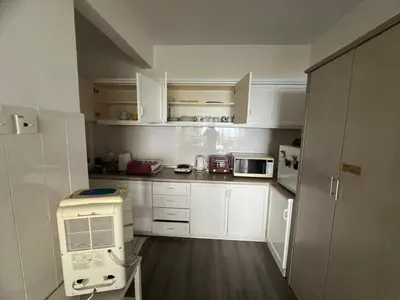 a small kitchen with white cabinets and a microwave at Misty at Fraser's Hill in Bukit Fraser