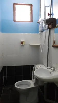 a bathroom with a toilet and a sink and a window at Pangkor Fish House in Pangkor