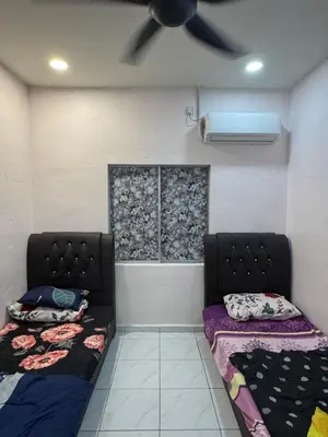 a room with two beds and a ceiling fan at Wika Homestay in Kulim