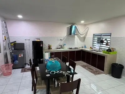 a kitchen with a table and a kitchen with a sink at Wika Homestay in Kulim