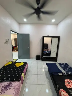 a room with two beds and a ceiling fan at Wika Homestay in Kulim