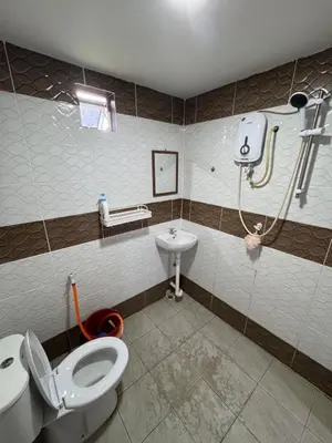 a bathroom with a toilet and a sink at Wika Homestay in Kulim