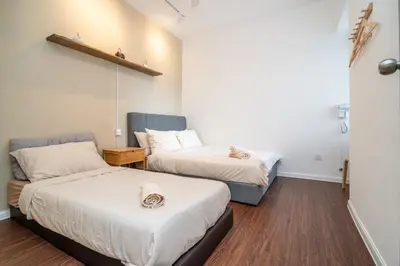 two beds in a small room with a bedskirts at Serene Japandi Family Retreat 2-7pax &Sunrise View in Brinchang