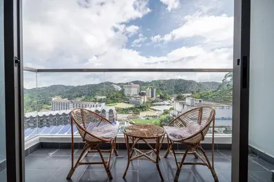 a balcony with two chairs and a view of a city at Serene Japandi Family Retreat 2-7pax &Sunrise View in Brinchang