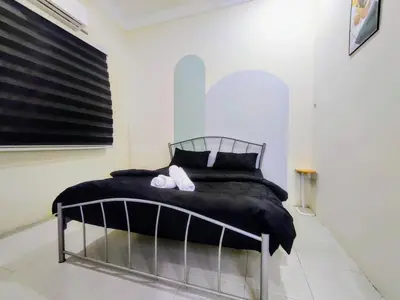 a bedroom with a black bed with white shoes on it at 13paxs Semi D Homestay Hutan Melintang in Hutan Melintang