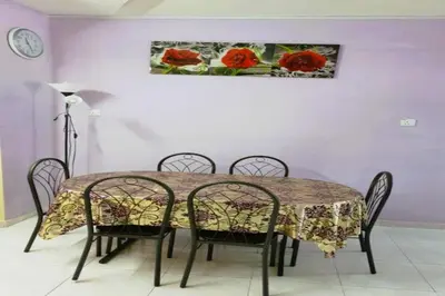 a dining room table with chairs and a painting of red roses at NO DEPOSIT - BIG Home 2-sty Terrace Near World Theme Park Hot Springs & Night Park max 6person in Ipoh