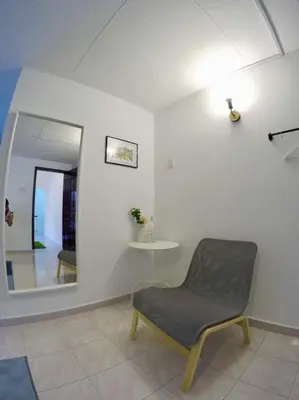 a room with a chair and a table and a mirror at 35Mandalay at Georgetown 5 bedroom for 7-15 pax in George Town