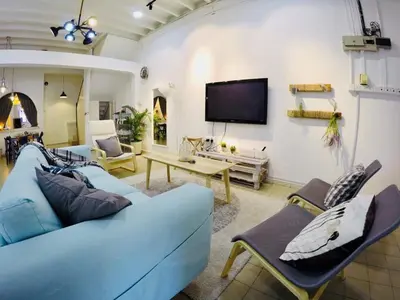 a living room with a blue couch and a tv at 35Mandalay at Georgetown 5 bedroom for 7-15 pax in George Town