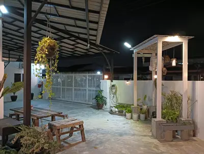a patio with benches and a pavilion at night at HT Home in Ipoh