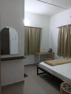 a bedroom with a bed and a tv on the wall at HT Home in Ipoh