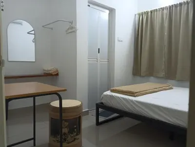 a bedroom with a bed and a desk and a mirror at HT Home in Ipoh