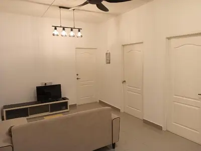 a living room with a couch and a tv at HT Home in Ipoh