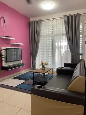 a living room with a black couch and pink walls at Homestay Sakura in Padang Serai