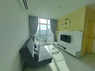 a living room with a couch and a clock on the wall at Straits Garden Suites Serenity Springs in Jelutong