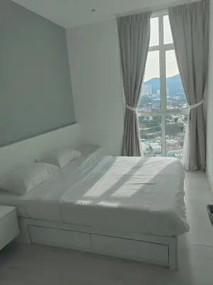 a bed in a bedroom with a large window at Straits Garden Suites Serenity Springs in Jelutong