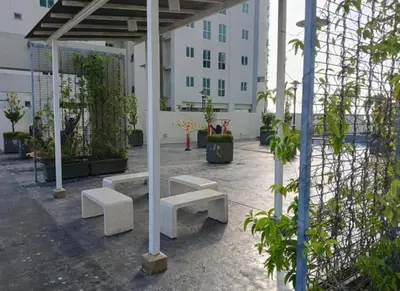 a group of benches in a courtyard with a building at Straits Garden Suites Serenity Springs in Jelutong