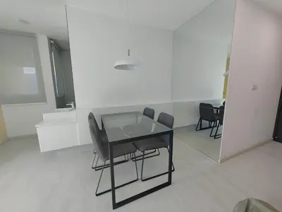 a dining room with a glass table and chairs at Straits Garden Suites Serenity Springs in Jelutong