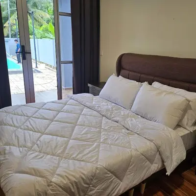 a bed with white sheets and pillows in a bedroom at Sastred villa Mus'lim Only in Sungai Petani
