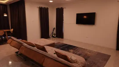 a living room with a couch and a flat screen tv at Sastred villa Mus'lim Only in Sungai Petani