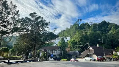 a town with cars parked in front of a mountain at FHCOMFYHOME B33A1 At SILVERPARK RESORT in Bukit Fraser