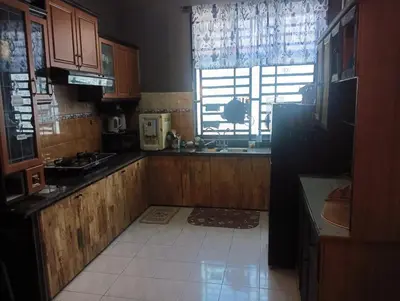 a kitchen with wooden cabinets and a large window at FF Lunas Homestay in Lunas
