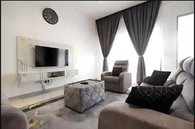 a living room with two chairs and a flat screen tv at Serene Terrace House 2-12pax &Sunrise View in Brinchang