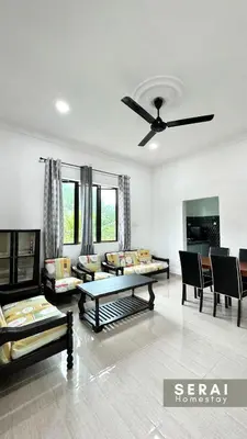 a living room with couches and a ceiling fan at SERAI Homestay in Gopeng