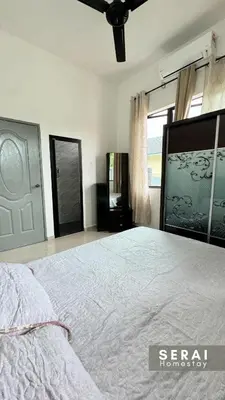a bedroom with a large bed and a window at SERAI Homestay in Gopeng