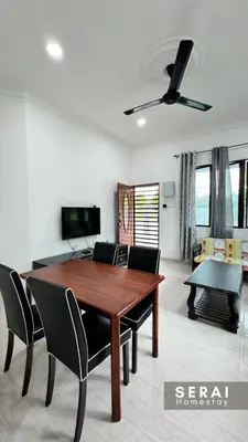a dining room table and chairs in a living room at SERAI Homestay in Gopeng