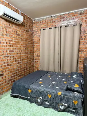 a bedroom with a bed in a brick wall at Bola-Bola DHomestay in Kepala Batas