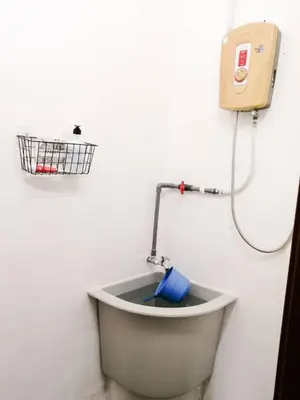 a bath tub with a hose attached to a wall at SK Sweet Homestay SP Kedah in Sungai Petani