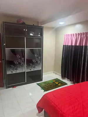 a bedroom with a dresser and a red bed at Airis Homestay Bertam Perdana in Kepala Batas