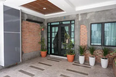 a patio with potted plants on the side of a building at Bricks Guesthouse in Tanah Rata