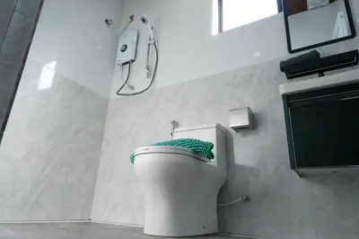 a white toilet in a bathroom with a sink at Bricks Guesthouse in Tanah Rata