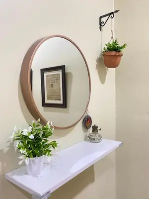 a round mirror on a white shelf with a plant at Yellow Retreat House Homestay Batu Gajah in Batu Gajah