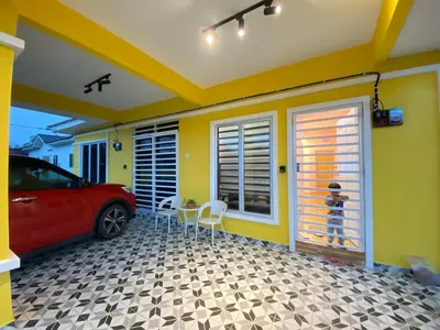 a garage with a red car parked in it at Yellow Retreat House Homestay Batu Gajah in Batu Gajah