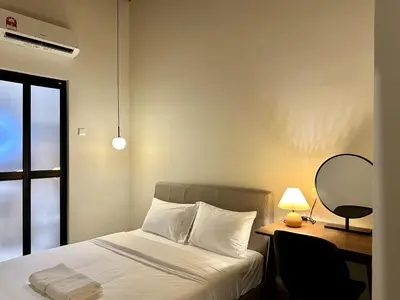 a bedroom with a bed and a desk with a lamp at Li's Inn in George Town