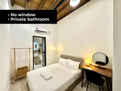 a bedroom with a bed and a desk with a mirror at Li's Inn in George Town