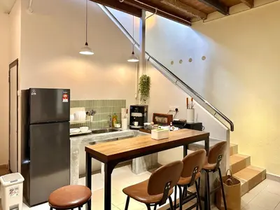 a kitchen with a table and chairs and a refrigerator at Li's Inn in George Town